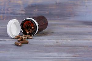 Pill bottle and scattered medical pills. Isolated medicaments. photo