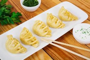 Delicious manti dumplings on wooden background photo