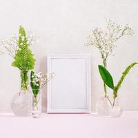 Flowers and plants in flask with frame. Beautiful spring background with flowers in vase. photo