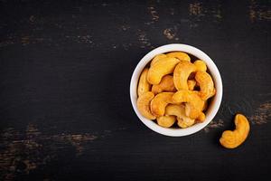 Cashews on dark wooden background. A handful of nuts. photo