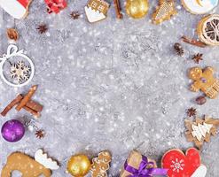 Christmas background. Christmas gift, toys, gingerbread cookies, spices and decorations on wooden background. Top view photo