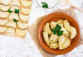 Delicious dumplings with cabbage on white background. Top view photo