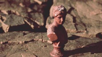 ancienne statue de femme sur des pierres rocheuses
