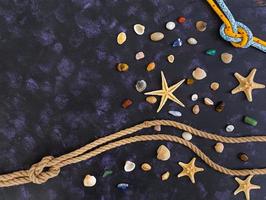 Seashell, starfish and rope on dark background. Top view photo