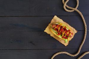 Delicious homemade hot dog on dark background photo