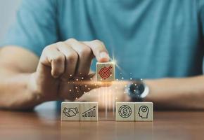 Hand arranging wood block stacking with business strategy and Action plan,targeting the business concept.business development concept. photo