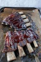 beef short ribs with barbecue sauce on baking tray flat lay photo