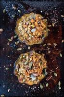 roasted acorn squash bowls filled with bread stuffing, nuts, and herbs on baking sheet flat lay