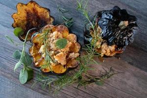 Baked acorn squash bowl with stuffing with rosemary and sage rustic flat lay