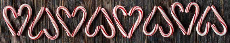 alternating direction candy cane heart border with copy space on rustic wood table flat lay photo