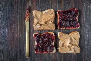 open peanut butter and jelly on sliced bread flat lay with knife photo