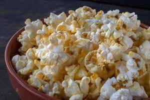 bowl of popped popcorn with torn open bag spilling out flat lay photo