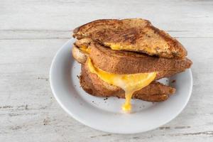 plated grilled cheese sandwich with dripping cheese photo