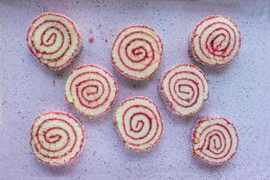Sliced rounds of jelly roll cake pieces on bright colorful background flat lay photo