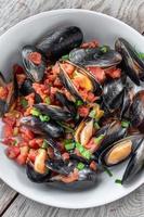 Steamed Mediterranean Seafood dish of Mussels with tomatoes and green onions flat lay photo
