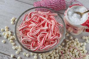 ingredientes para hacer dulces navideños con bastones de caramelo y chispas de chocolate blanco endecha plana foto