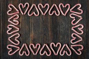 alternating direction candy cane heart border with copy space on rustic wood table flat lay photo