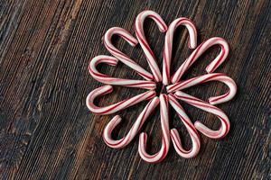 candy canes in a flower design on rustic wood table flat lay photo