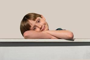 smiling happy young boy with brown eyes on frame edge with copy space photo