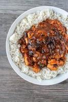 pollo glaseado al curry sobre arroz blanco plano