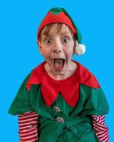Surprised boy dressed as Christmas elf on blue-screen background photo