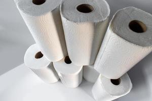Abastecerse de suministros con una pila de toallas de papel blanco sobre fondo blanco. foto