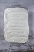 rectangle glass pan with vanilla pudding frosting swirled on top flat lay photo
