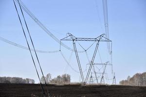 Ultra-high voltage power line in the field in spring in Russia