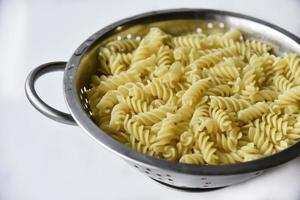 Boiled vermicelli noodles horns in a colander photo