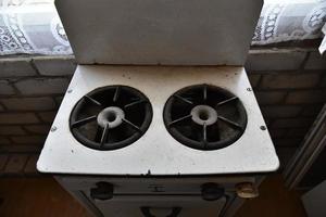 Old two-burner white gas stove in the room photo