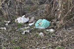 Garbage and household waste on the riverbank from vacationers. Environmental pollution. photo