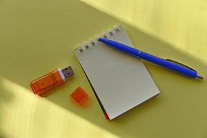 pluma estilográfica azul y bloc de notas sobre un fondo amarillo foto