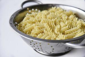 Boiled vermicelli noodles horns in a colander photo