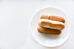 Three hot dog buns on a plate photo