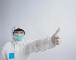 Doctor in PPE suit gesture make hand sign. Represent victory win over virus. photo