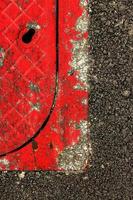 tapa de alcantarilla roja sonriendo en el asfalto. imagen vertical foto