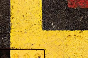 Asphalt painted yellow and red, suitable for textured abstract background. photo