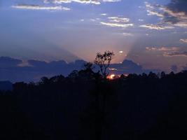 Sunset dawn mountain raylighs bluesky clouds silhouette trees photo