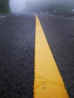 yellow stripe line painted on the asphalt road for traffic sign photo