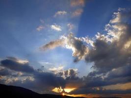 rayo de luz en el cielo azul brillante de la puesta del sol del amanecer foto