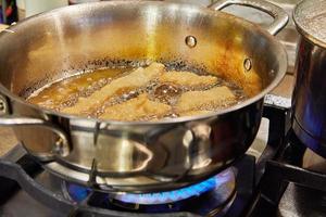 Bugnes, French donuts in boiling oil in saucepan photo