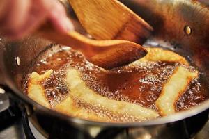 Bugnes, French donuts in boiling oil in saucepan photo