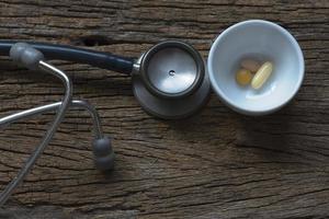 Pills in a cup and stethoscope photo