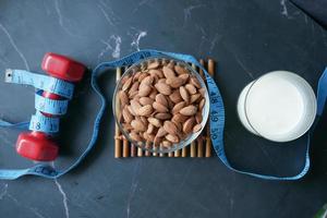 almond nut, dumbbell and milk on table photo