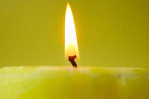 yellow color candles slowly burning down. photo