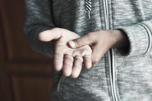 man suffering pain in hand close up photo