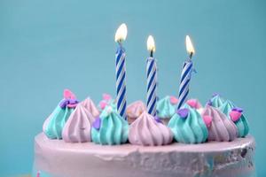 velas encendidas en un pastel de cumpleaños con fondo de color