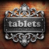 tablets word of iron on wooden background photo
