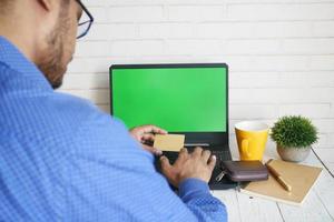 man hands holding credit card and using laptop shopping online photo