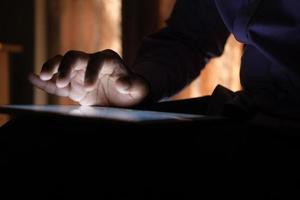 man hand using digital tablet on black background photo